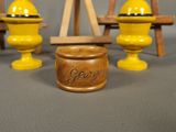 three yellow vases are sitting on a table next to a wooden easel