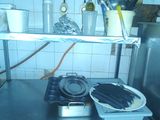 a kitchen with a stove, sink, and pots on the counter