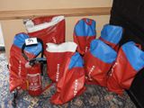 Des sacs d'extincteurs sont alignés sur le sol, à côté d'un extincteur