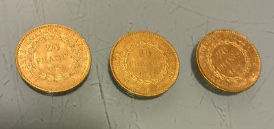 three gold coins sitting on top of a table next to each other
