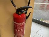 un extincteur fixé au mur d'un immeuble