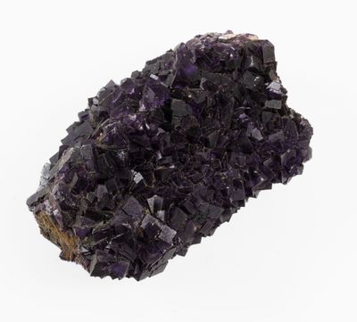 a close up of a cluster of purple crystals on a white surface