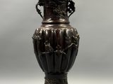 un vase en bronze posé sur une table