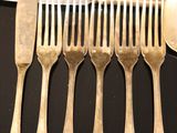 a lot of forks and spoons that are on the table