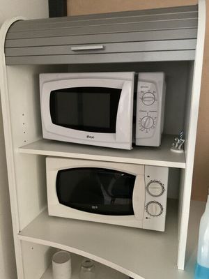 deux micro-ondes posés l'un à côté de l'autre sur une étagère