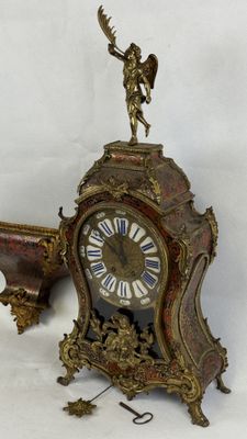 une horloge posée par terre, sur laquelle se trouve un oiseau
