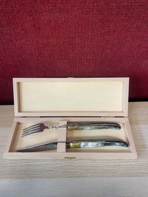 a knife and fork in a wooden box on a table