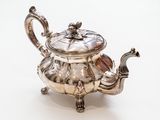 une théière ancienne en argent avec son couvercle, sur fond blanc