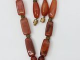 un collier avec un pendentif en forme de cœur et deux perles en cornaline