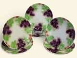 trois morceaux de verre ornés de fleurs violettes, posés sur une surface blanche