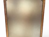 une image d'un miroir encadré d'or sur un fond blanc