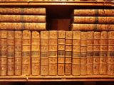 many old books on a wooden shelf in a room
