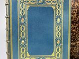 an old book with a blue cover and a gold border