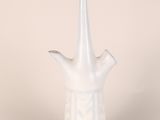 a white vase that has a handle on it
