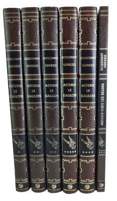 six livres empilés les uns sur les autres sur une surface blanche