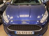 the front of a blue ford fiesta parked in a garage