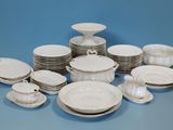beaucoup d'assiettes et de bols blancs sur la table