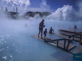 un homme debout sur un quai au bord d'un plan d'eau d'où s'échappe de la vapeur