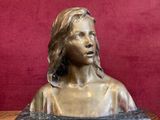 statue d'une femme assise sur une table, avec un mur rouge en arrière-plan
