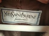 the label of a white fur coat that says yves saint laurent