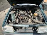 a blue car with its hood open and the engine in the trunk