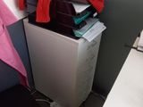 a small refrigerator with a pile of clothes on top of it