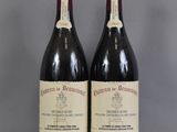 two bottles of wine sitting on top of a table next to each other