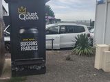 cars parked in a parking lot next to a building with a sign on the side of it
