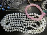 a lot of pearls and other jewelry on a table