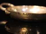 a close up of a silver bowl on a black surface