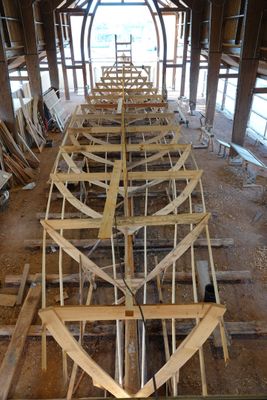 un grand bateau en bois en cours de construction dans un hangar