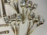 a lot of silver spoons and forks on the table