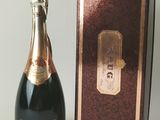 une bouteille de champagne posée à côté d'une boîte