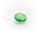 a close up of a green emerald stone on a white surface