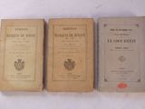 trois vieux livres posés les uns à côté des autres sur une table blanche
