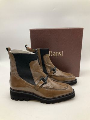 une paire de bottes beiges à semelles noires et une boîte marron