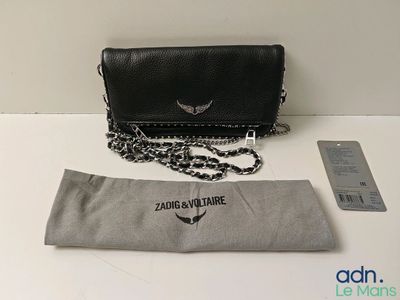 an image of a black purse with a silver chain on a table
