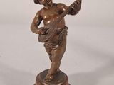 bronze figurine of a boy playing a guitar on a pedestal