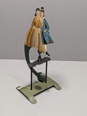 sculpture of a man and a woman on a globe on a stand