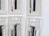 several different types of pens are in plastic cases on a white surface