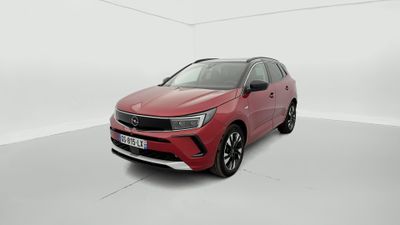 une voiture rouge dans une pièce blanche au sol blanc