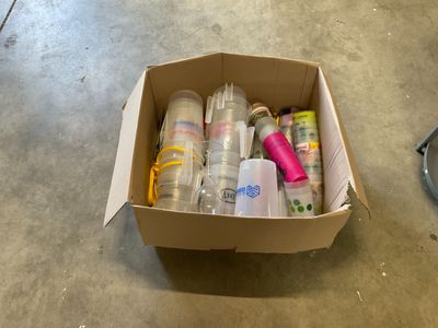 une boîte en carton posée par terre et remplie d'objets divers