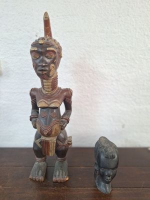 two figurines of a man and a dog sitting on a table