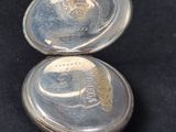 a silver pocket watch with a picture of a man on it