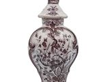 a brown and white vase with a bird on top of it