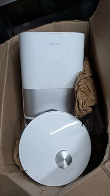 a toilet in a cardboard box with a trash can in it