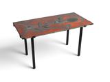 La table est en métal et présente une finition rouge « patt ».