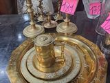 un plateau en or sur lequel est posée une bougie, posé sur une table