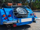 a small blue car parked on the side of the road