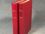 two red books sitting on top of each other on a gray surface